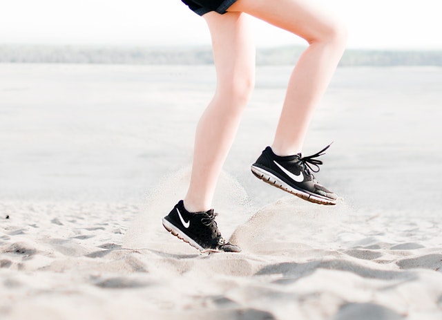 photo of woman wearing pair of black nike running shoes 1166868