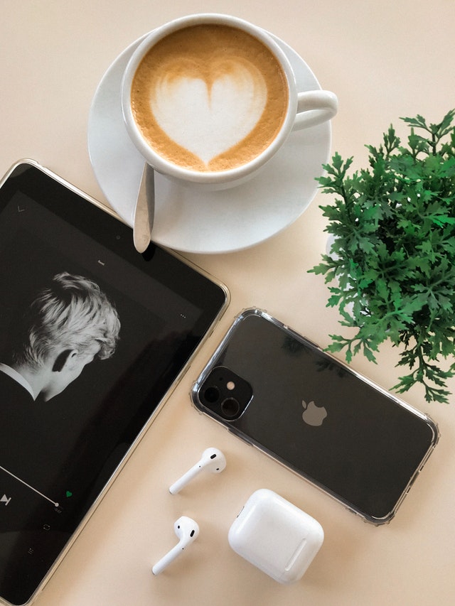 black iphone 11 beside airpods and coffee cup 3250815